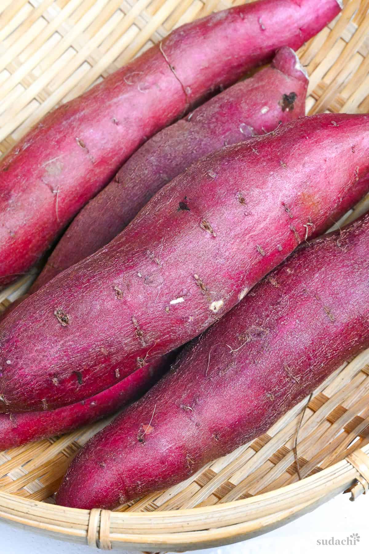 4 beni haruka sweet potatoes in a bamboo woven basket