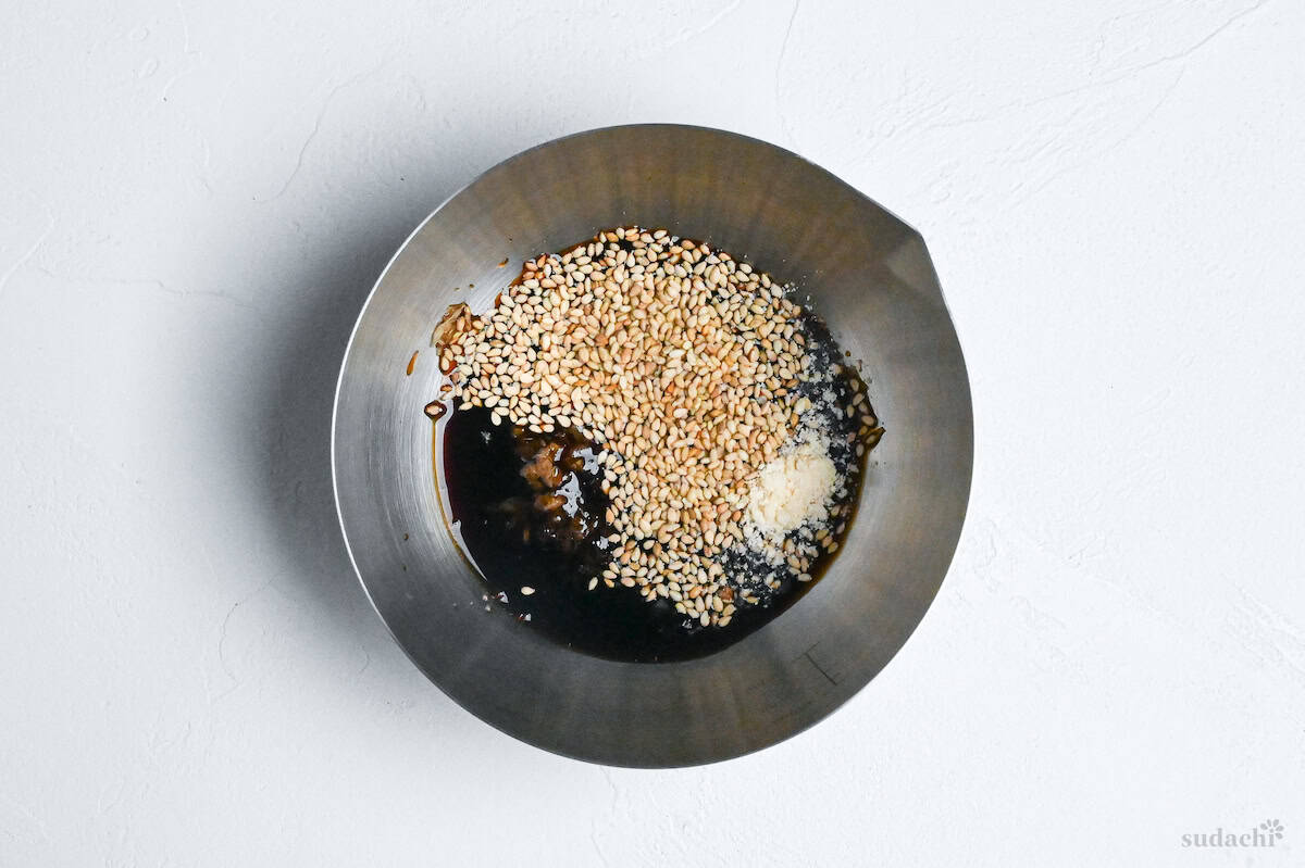 Ingredients to make yakiniku restaurant style salad dressing in a steel mixing bowl on a white background
