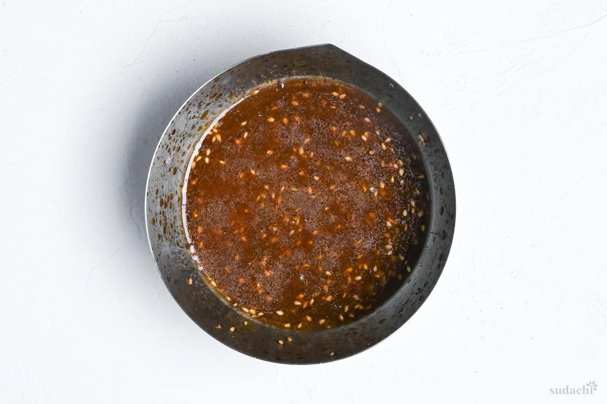 yakiniku restaurant style salad dressing in a steel mixing bowl on a white background