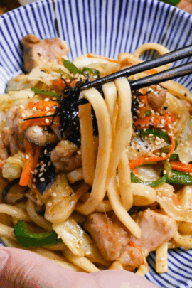 holding chicken butter shoyu yaki udon with chopsticks