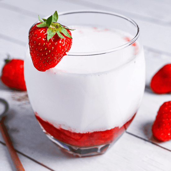 Japanese strawberry milk in a glass with a strawberry on the rim
