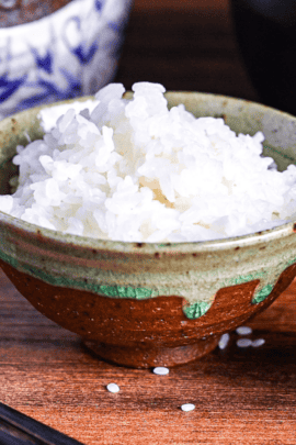 raw japanese rice in a green Japanese rice measuring cup