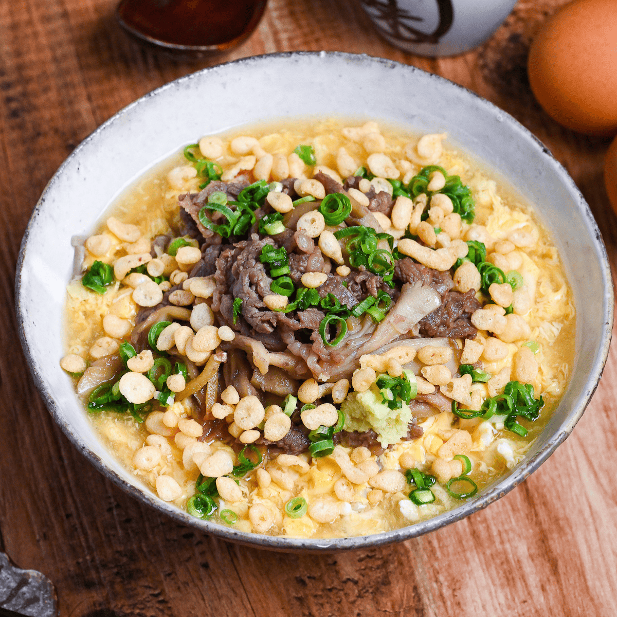 Nikutama Ankake Soba (Beef & Egg Soba Noodle Soup) in a white and brown bowl
